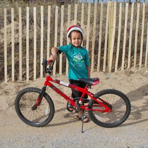 Child standing next to rental bicycle