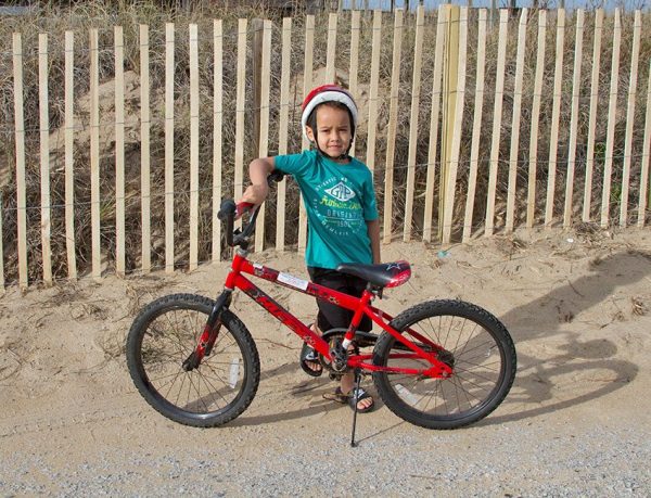 Child standing next to rental bicycle